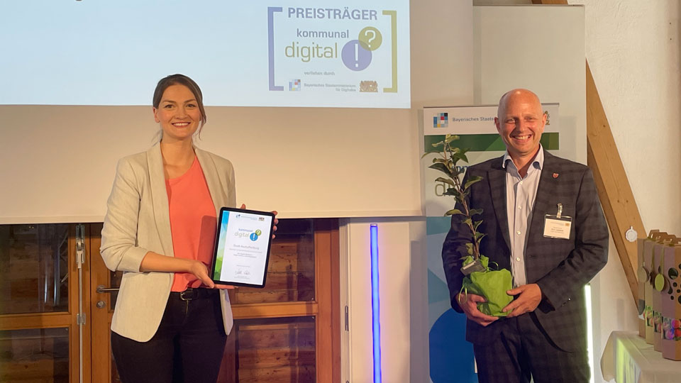Die Bayerische Staatsministerin für Digitals Judith Gerlach, MDL, übergibt den Preis für die „Digitale Manufaktur“ an Bürgermeister und Digitalreferent Eric Leiderer.